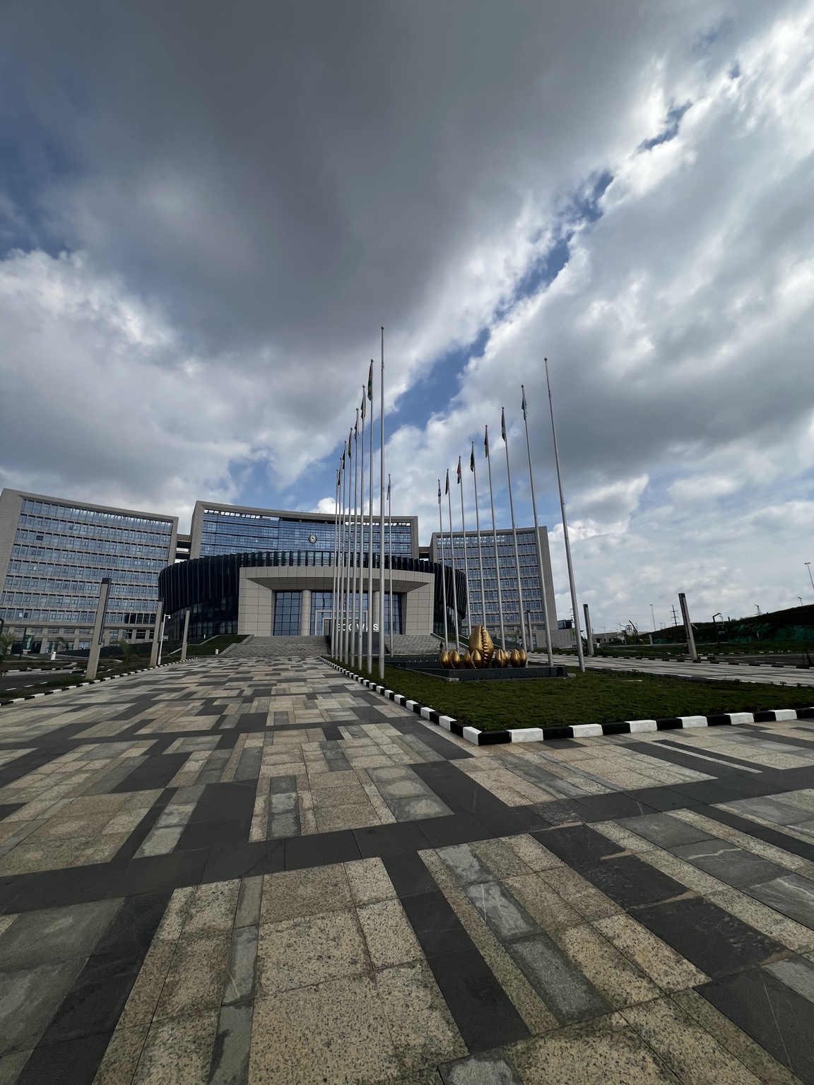 ECOWAS headquarters exterior with flags along the approach
