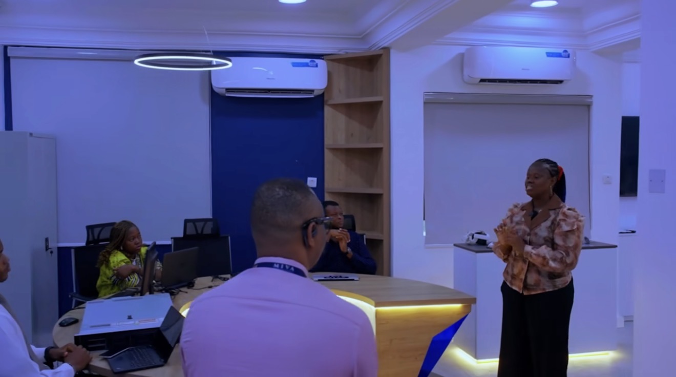 A presenter speaks to people seated at the round table in the Miva Open University Robotics & Innovation Laboratory